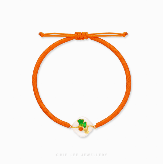 A close-up of a 999 Pure Gold Adjustable Baby Bracelet, showing the detailed gold floral piece and a smooth He Tian Yu (Jade) bead.