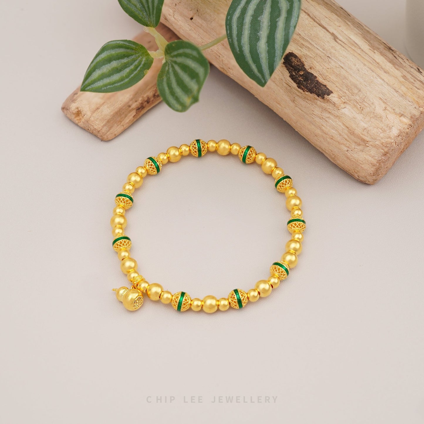 999 Pure Gold Fortune Gourd Gu Fa Jin Bracelet with symbolic gourd charm and green accents, crafted with ancient goldsmithing techniques.