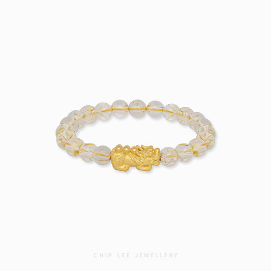 Close-up of 999 Pure Gold Tri-Ingot Clarity Pixiu Bracelet featuring a gold Pixiu charm and three ingot motifs on display.