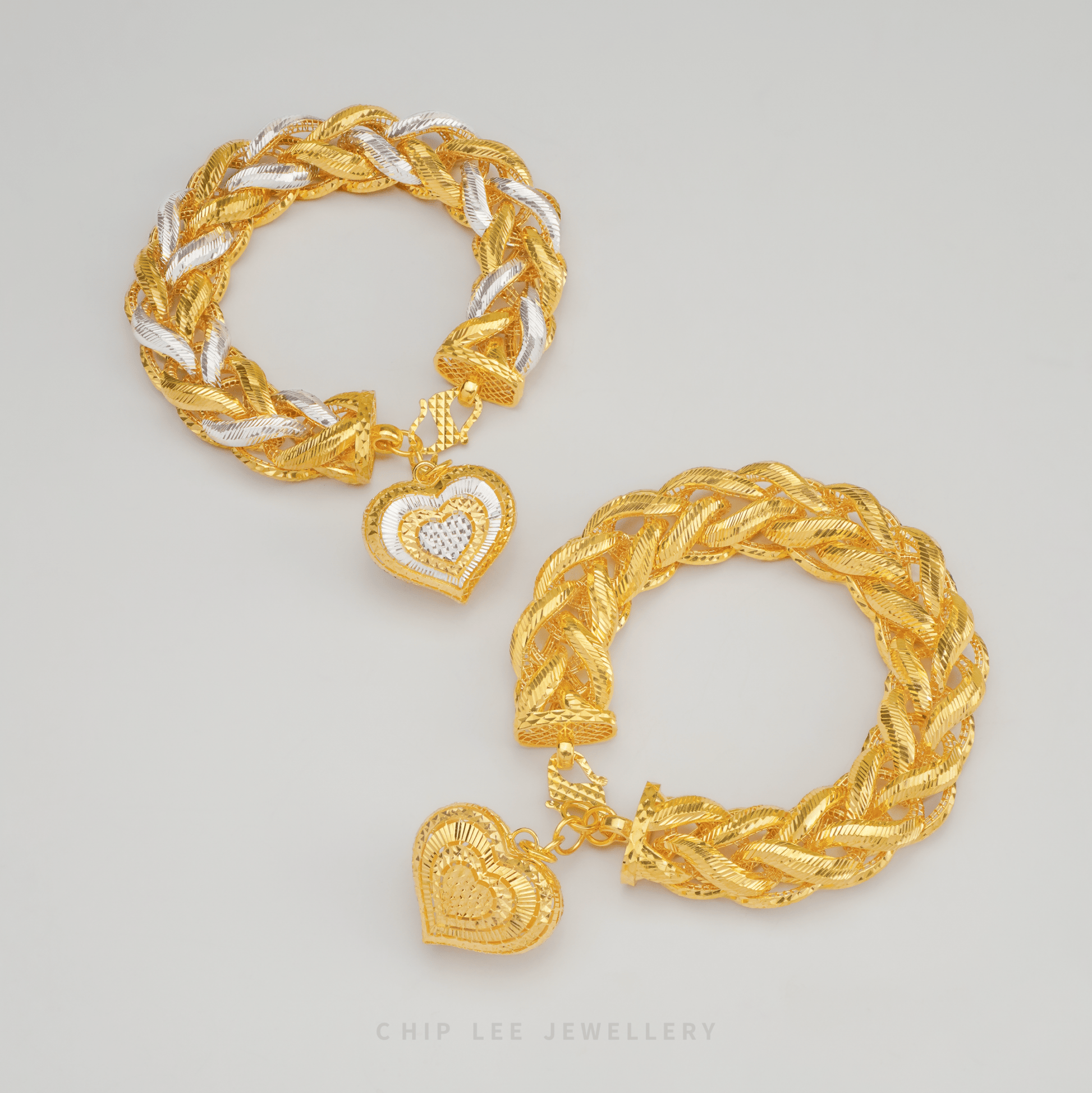 Gold and silver braided bracelet with heart charm on a light gray background