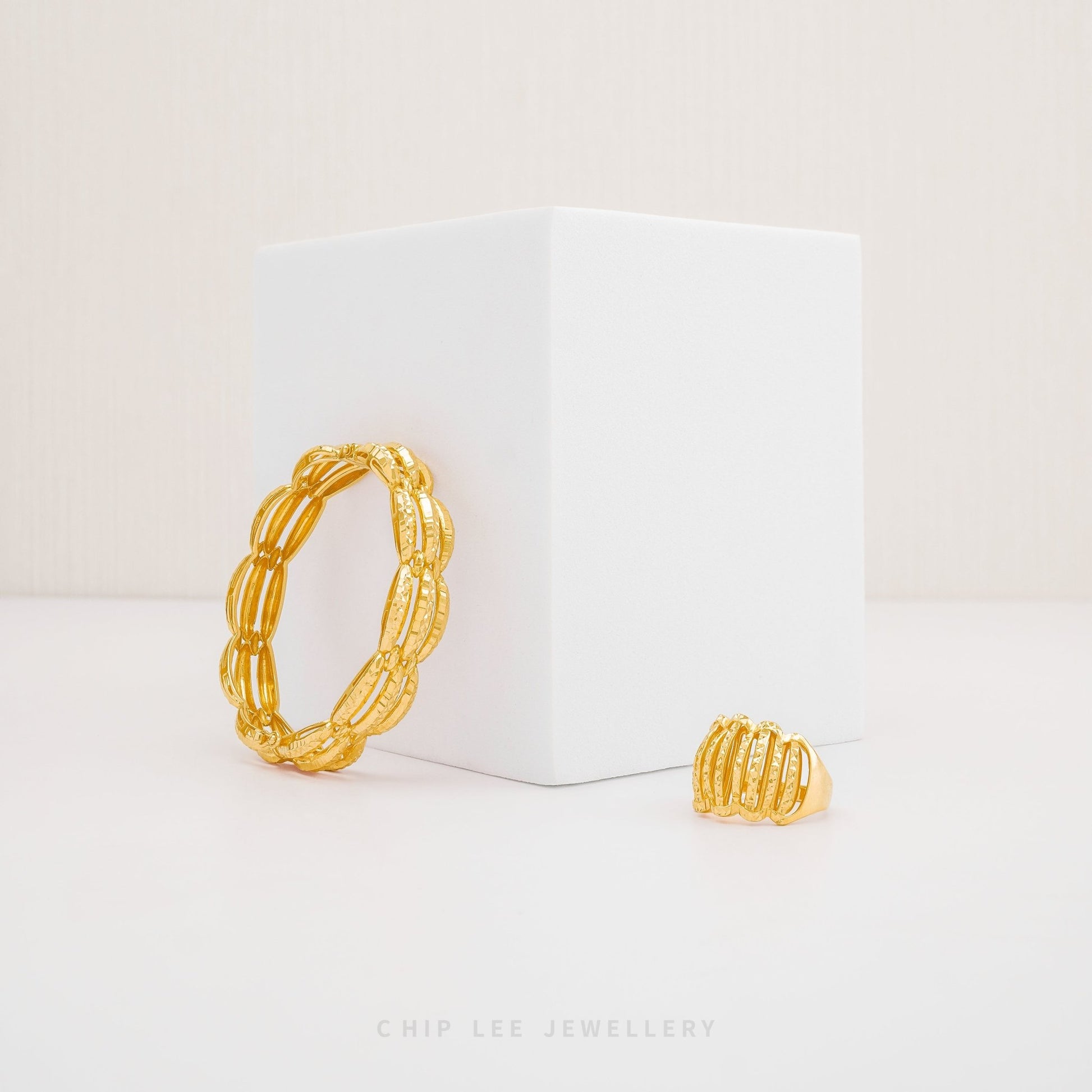 Chunky Trinity Bangle by Chip Lee Jewellery Singapore, 916/22K gold, three-tone intertwined design, symbolizes unity and strength, bold statement piece.