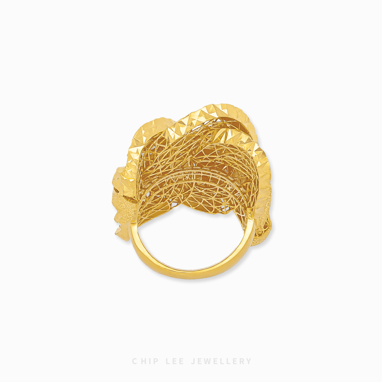 Gold ring with intricate design on a white background