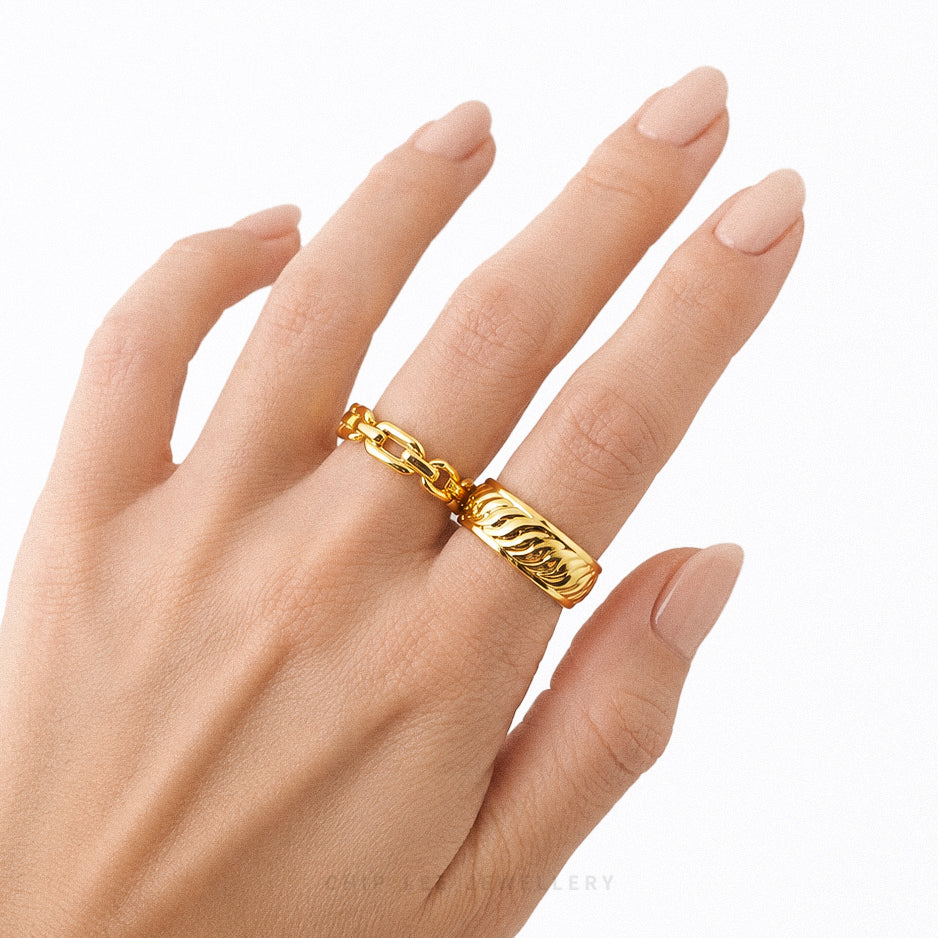 Gold ring on a hand against a white background