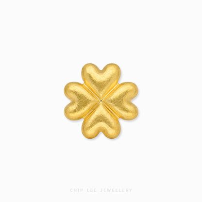 A textured gold four-leaf clover charm or brooch, centered on a clean white background with a subtle drop shadow. The brand name 'CHIP LEE JEWELLERY' is faintly visible at the bottom.