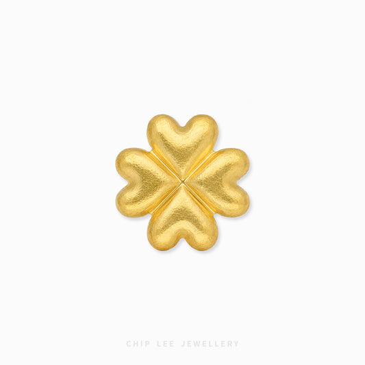 A textured gold four-leaf clover charm or brooch, centered on a clean white background with a subtle drop shadow. The brand name 'CHIP LEE JEWELLERY' is faintly visible at the bottom.