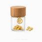 A small clear glass jar with a light wood lid holds several gold flower-shaped charms, with one charm hanging from the jar and two more placed beside it on a white background. The text 'CHIP LEE JEWELLERY' appears faintly at the bottom.