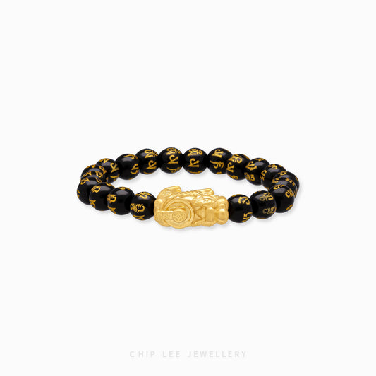 Close-up of 999 Pure Gold Black Agate Pixiu Bracelet with black agate beads and gold Pixiu charm on display.