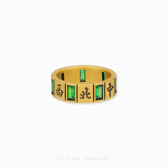 A detailed close-up of the 999 Pure Gold Black Mystic Mahjong Ring, showing the polished gold, a black mahjong tile, and a vibrant green cubic zirconia.

