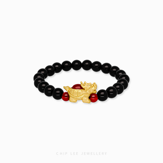 Close-up of 999 Pure Gold Black and Red Agate Pixiu Bracelet featuring gold Pixiu charms and black and red agate beads on display.