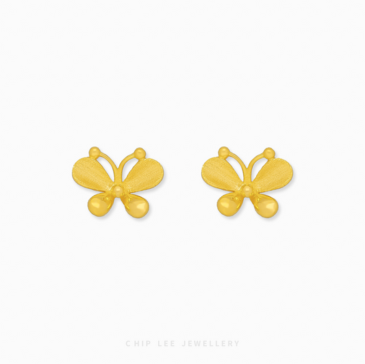 A close-up of a pair of bright yellow 999 pure gold butterfly stud earrings, displayed against a white background.