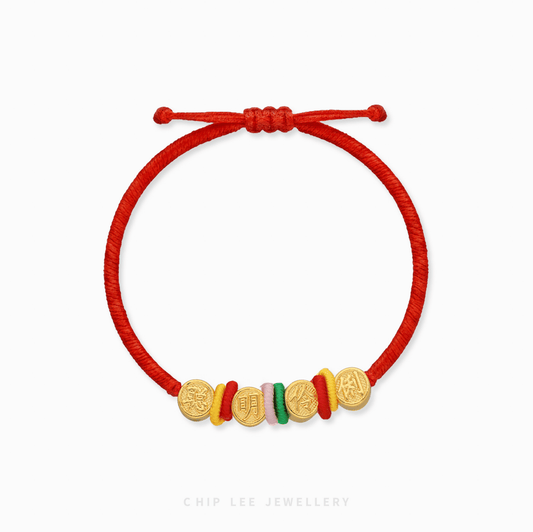 A close-up shot of a 999 Pure Gold (聪明伶俐) Cong Ming Ling Li Baby Bracelet, showing the detailed gold charm.
