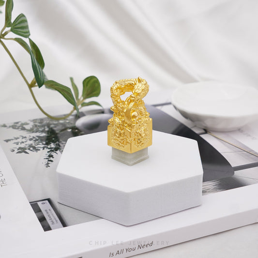 999 pure gold dragon pendant embracing He Tian jade seal, symbolizing power, fortune, protection in a refined traditional jewellery design.