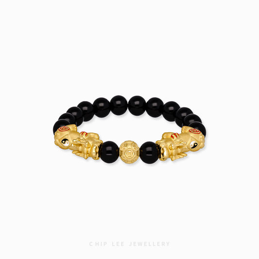 Close-up of 999 Pure Gold Duo Yin Yang Black Agate Pixiu Bracelet with black agate beads and dual Pixiu charms on display.