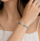 Blue bracelet with a colorful clasp on a white background