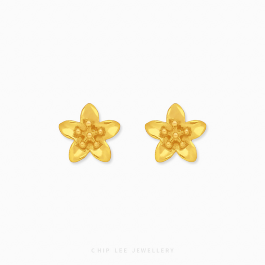 A pair of bright yellow 999 pure gold floral stud earrings with a detailed petal design and high-shine finish, presented on a white backdrop.