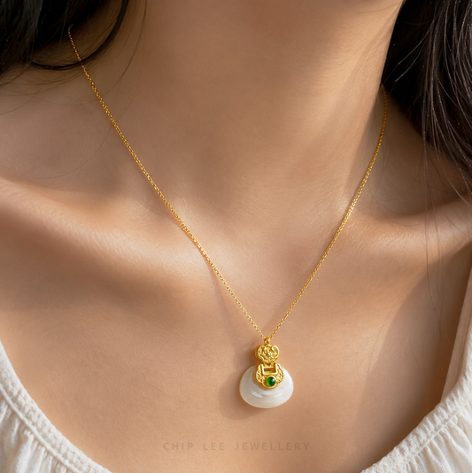 Gold jade pendant with a green gemstone
