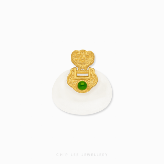 Gold pendant with a green gemstone on a white background