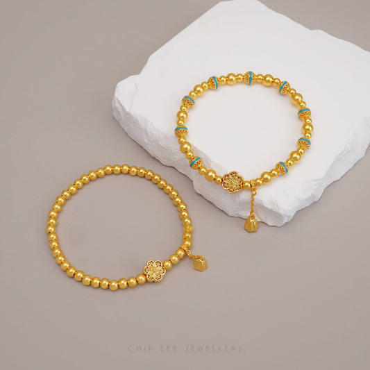 Two intricate 999 pure gold Gu Fa Jin bracelet on a flatlay background.