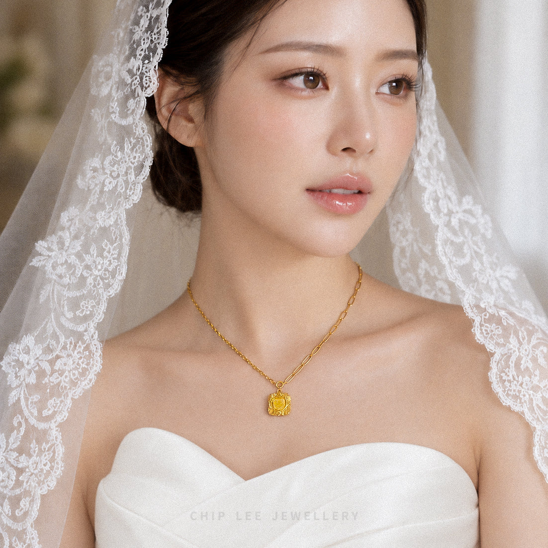 A close-up portrait of a woman wearing a delicate gold necklace with a square yellow gemstone pendant, styled with a white lace bridal veil and a white strapless dress. The brand name 'CHIP LEE JEWELLERY' is visible at the bottom.