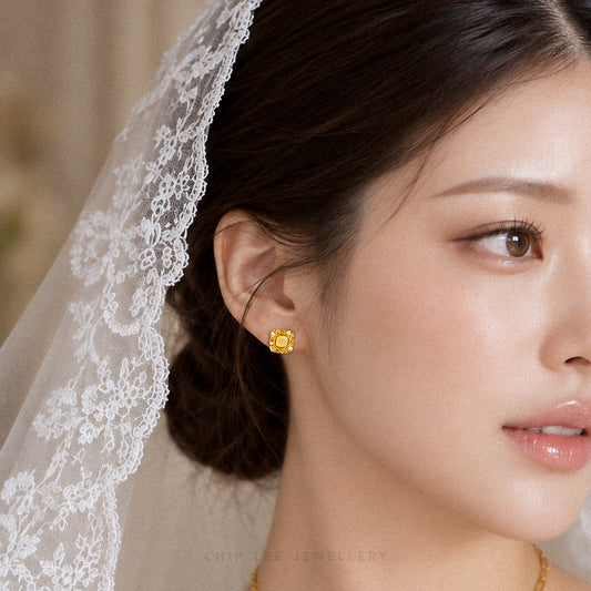 A close-up of a woman wearing a delicate gold stud earring with a square-cut clear gemstone and a white lace veil. The brand name 'CHIP LEE JEWELLERY' is faintly visible at the bottom.