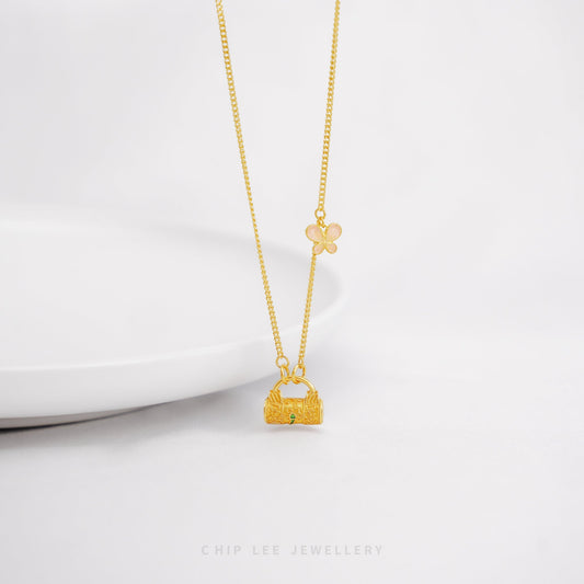 Gold necklace with a small lock charm pendant on a white background