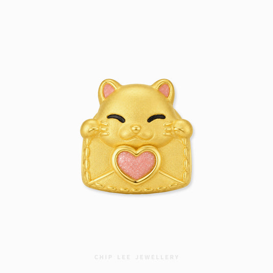 A gold cat-shaped charm with a pink glitter heart on its chest, featuring black line details for closed eyes and a smiling mouth, set against a plain white background.