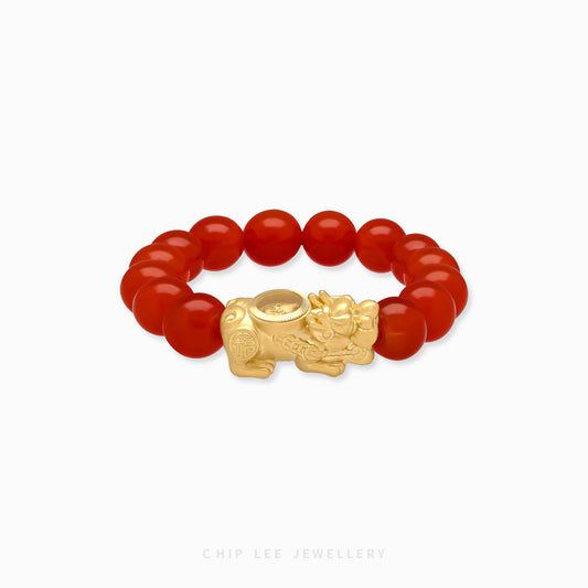 Close-up of 999 Pure Gold Red Agate Pixiu Bracelet with red agate beads and gold Pixiu charm on display.