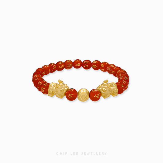 Close-up of 999 Pure Gold Red Agate Twin Baby Pixiu Bracelet featuring twin gold Pixiu charms and red agate beads on display.