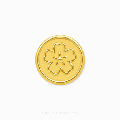 A round gold button with an embossed five-petal flower motif, centered on a plain white background with 'CHIP LEE JEWELLERY' printed faintly at the bottom.
