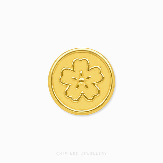 A round gold button with an embossed five-petal flower motif, centered on a plain white background with 'CHIP LEE JEWELLERY' printed faintly at the bottom.