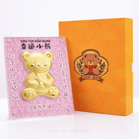 999 gold Lucky Bear collectable displayed in a clear acrylic frame with an orange gift box, featuring cheerful bear design and auspicious Chinese blessings.