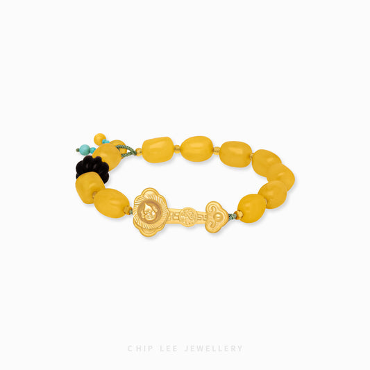 Close-up of 999 Pure Gold Yellow Agate Prosperity Bracelet with yellow agate beads and gold charm on display.