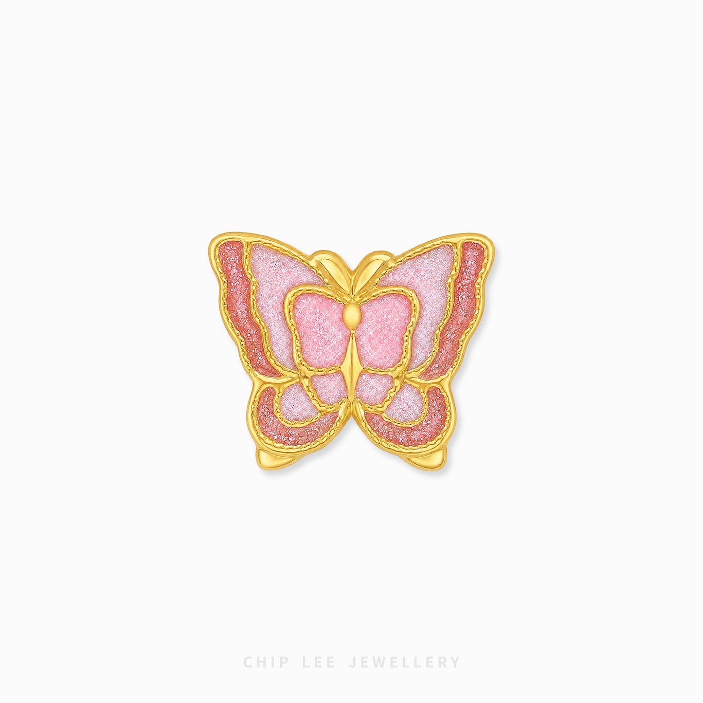 A butterfly-shaped brooch by Chip Lee Jewellery, featuring a gold-tone metal border and a textured pink enamel center with glittery rose-pink outer borders, set against a plain white background.