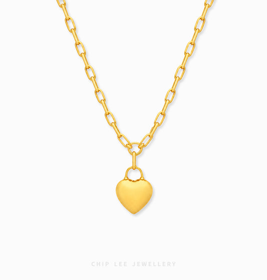 A gold heart pendant necklace on a matching gold chain, shown against a plain white background with a faint 'CHIP LEE JEWELLERY' watermark at the bottom.