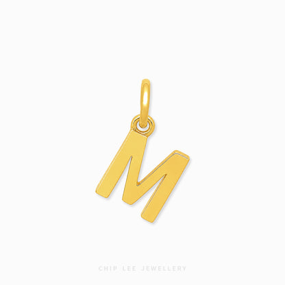 A polished yellow gold initial pendant charm shaped like the letter 'M', shown on a clean white background with a subtle shadow.