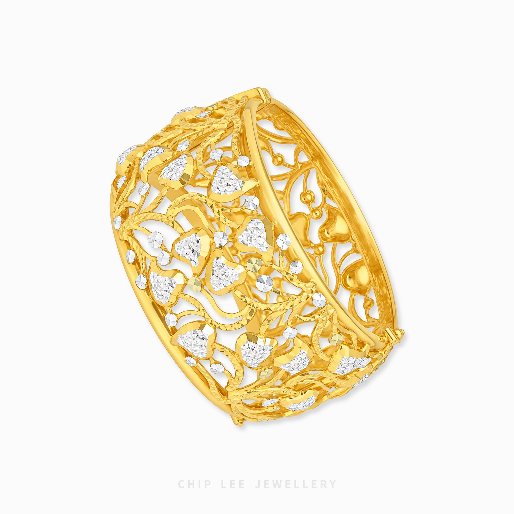 A wide yellow gold filigree ring featuring intricate openwork floral and leaf patterns set with small clear stones, shown on a clean white background with a Chip Lee Jewellery watermark.
