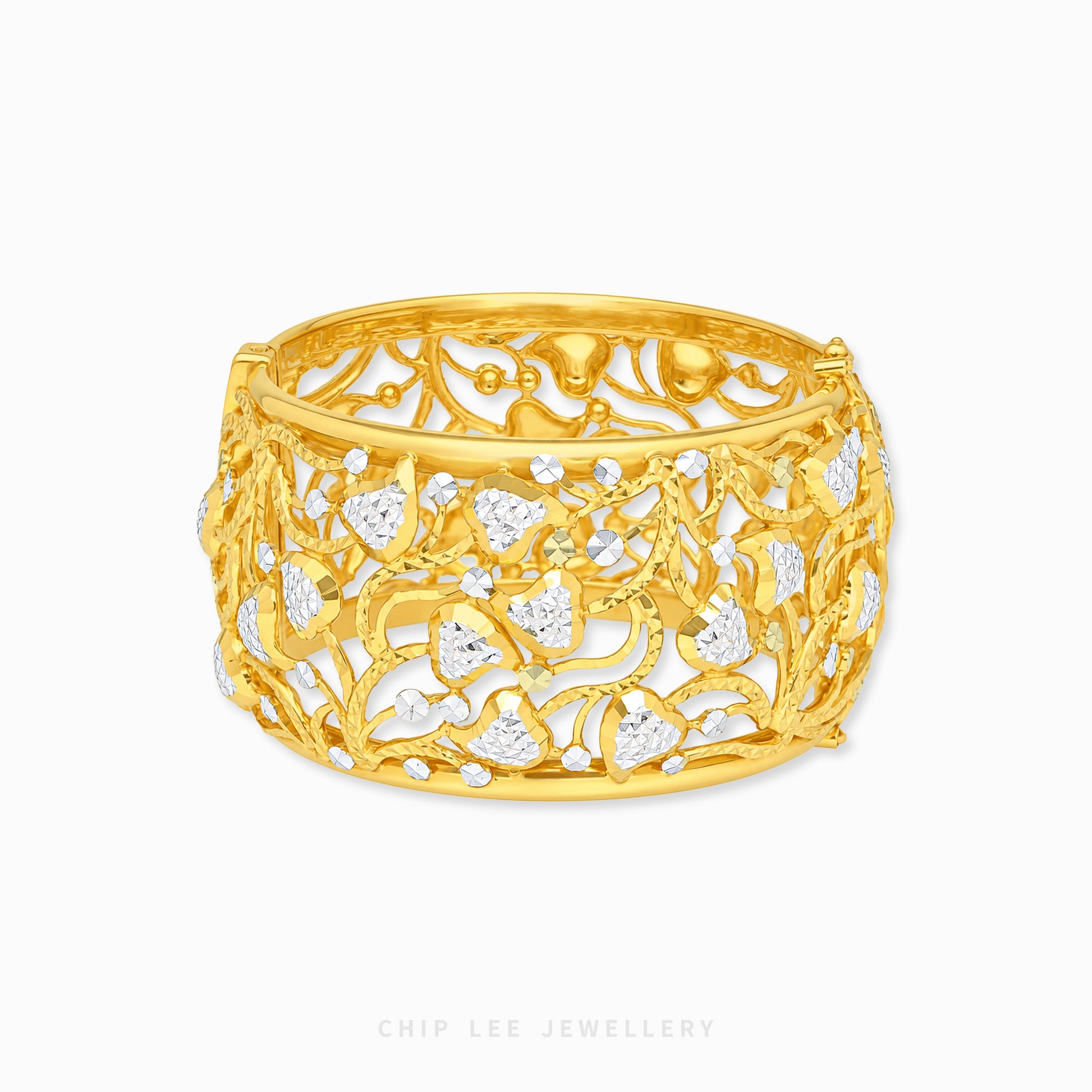 A wide yellow gold filigree cuff bracelet with openwork floral and vine patterns, accented with small clear stones, shown on a plain white background. The brand name 'CHIP LEE JEWELLERY' is printed in small text at the bottom.