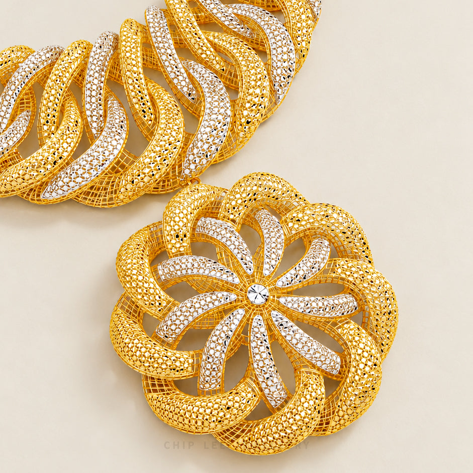Gold and silver rhinestone-embellished chain link jewelry shown in a close-up studio shot on a light beige background.