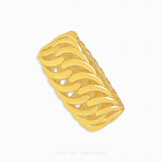 Gold bangle with wavy design on a white background