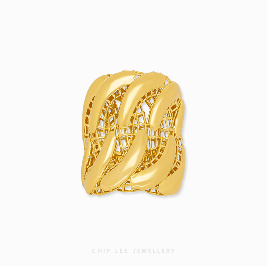 Gold ring with intricate design on a white background