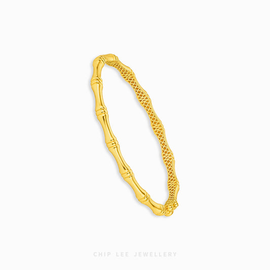 A gold bangle bracelet with a textured bamboo-inspired design on one side and a woven pattern on the other, shown on a light gray background with the brand name 'CHIP LEE JEWELLERY' at the bottom.