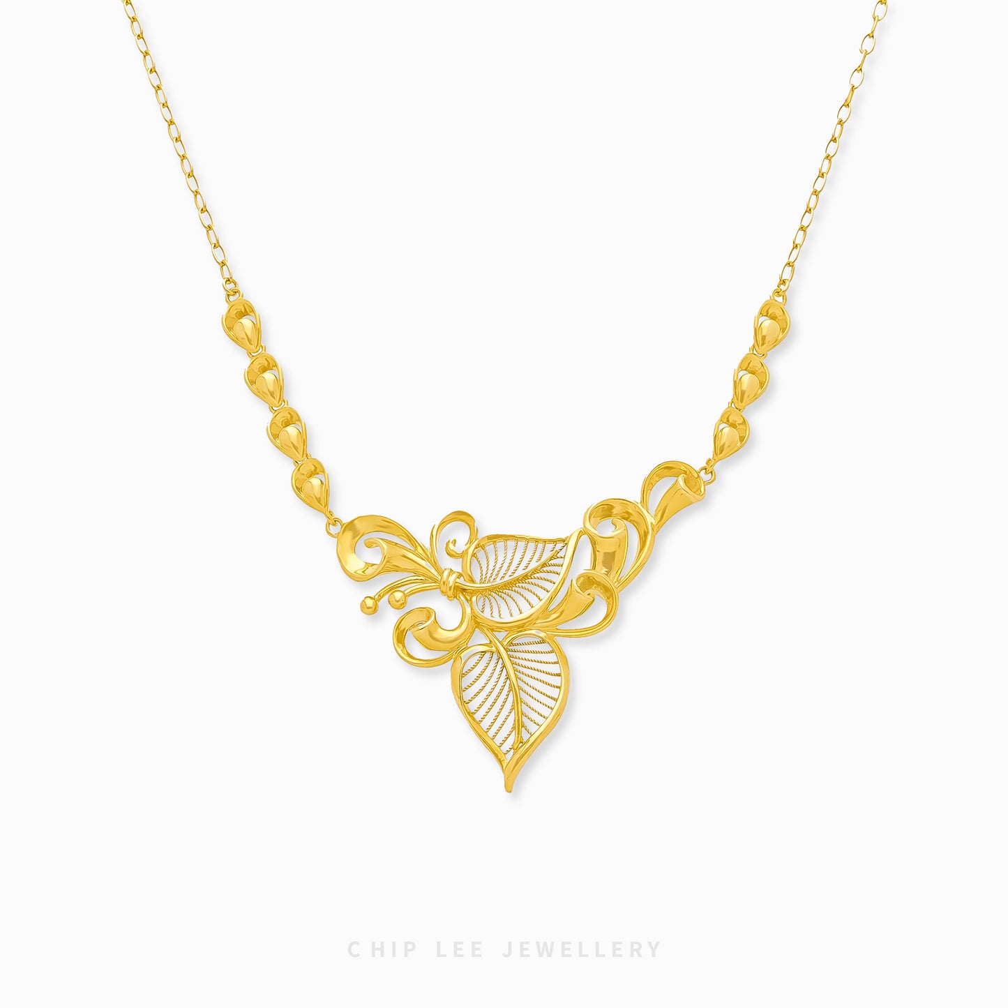A gold necklace with a floral motif pendant at the center, displayed against a white background.