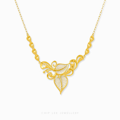 A gold necklace with a floral motif pendant at the center, displayed against a white background.