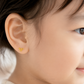 A close-up of a child's ear wearing a small gold bow-shaped stud earring, with the child's face partially visible on the right. The text 'CHIP LEE JEWELLERY' appears faintly at the bottom.