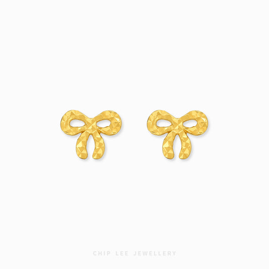 A pair of gold bow-shaped stud earrings with a textured, faceted surface, displayed on a clean white background with the brand name 'CHIP LEE JEWELLERY' printed at the bottom.