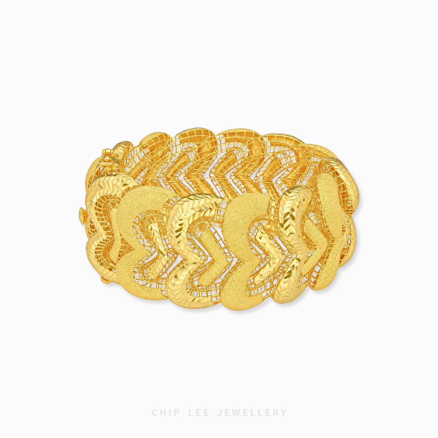A wide gold chain bracelet with textured chevron links, displayed on a clean white background with a brand watermark at the bottom.