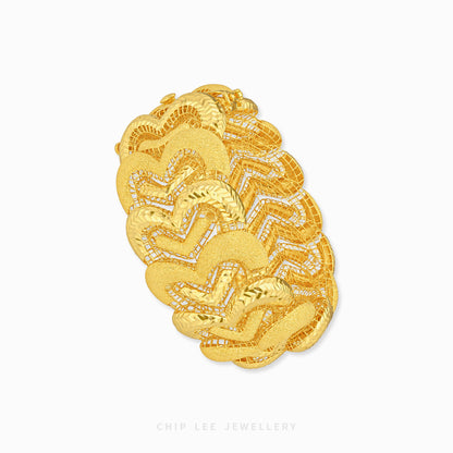 A chunky gold bangle bracelet with a textured, layered chevron pattern and small pavé-set clear stones, shown on a plain white background with a Chip Lee Jewellery watermark at the bottom.