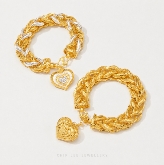 Gold and silver braided bracelet with heart charm on a light gray background