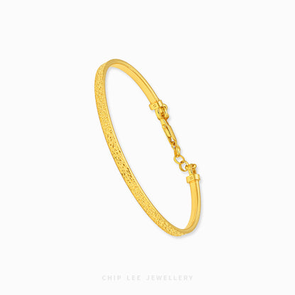 A textured yellow gold hinged bangle bracelet with a lobster clasp, shown on a clean white background with the brand name 'CHIP LEE JEWELLERY' at the bottom.