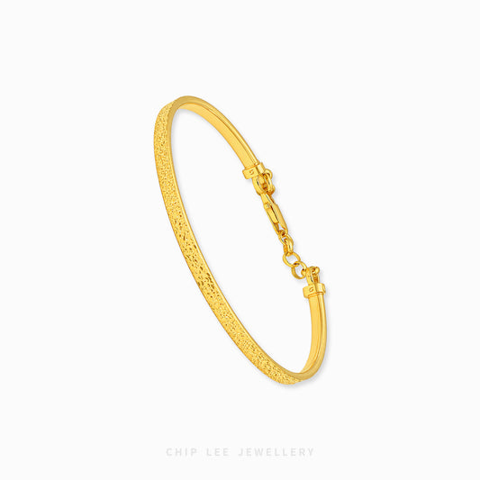 A textured yellow gold hinged bangle bracelet with a lobster clasp, shown on a clean white background with the brand name 'CHIP LEE JEWELLERY' at the bottom.